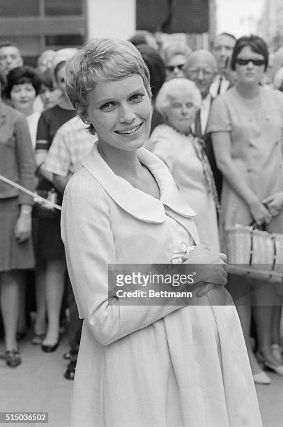 Actress Mia Farrow flashes a bright smile as she arrives for on "location" filming here on August 27th, for the movie Rosemary's Baby. Miss Farrow,...