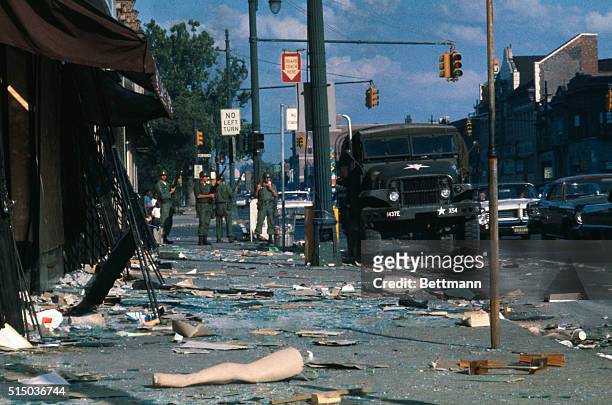 National Guardsmen stand guard amid the rubble and debris tossed onto a sidewalk on Detroit's west side during the days of rioting and looting by...