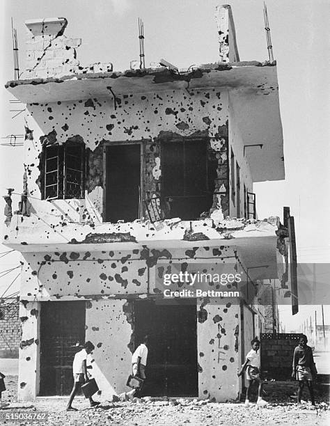 Damaged by Fighting. Aden, South Yemen Republic: Young Arab school-children on their way to school pass one of the buildings that was damaged during...