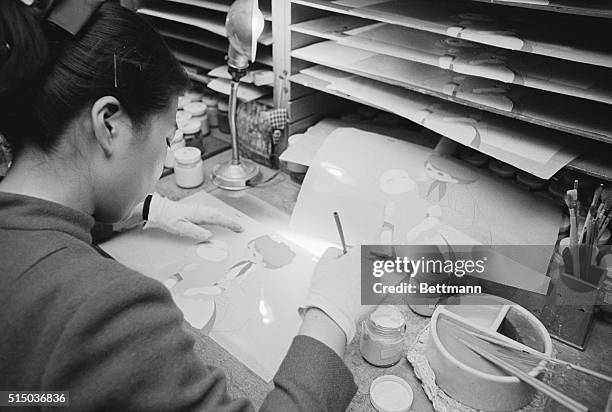 Woman at Toei Studios hand-paints a series of animation cells.