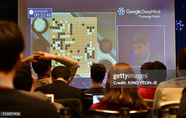 Journalists watch a big screen showing live footage of the third game of the Google DeepMind Challenge Match between Lee Se-Dol, one of the greatest...