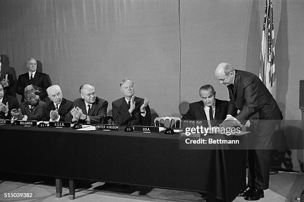 This is the scene in the East Room of the White House October 10th as President Johnson is applauded and congratulated after signing a document...