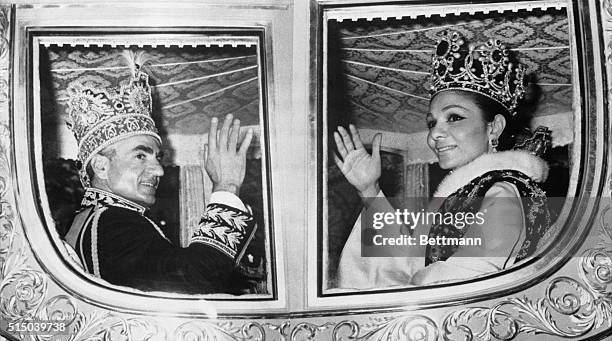 Big Day. Tehran, Iran: The shah of Iran and Empress Farah wave from their carriage as they ride through the streets of Tehran after their coronation...