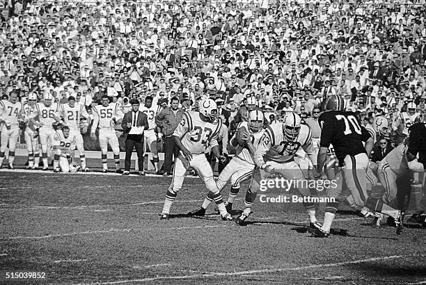 Baltimore Colts' Johnny Unitas gets behind teammates Sam Ball and Tom Lorick for protection against Atlanta Falcons' Jim Norton as he prepares to...