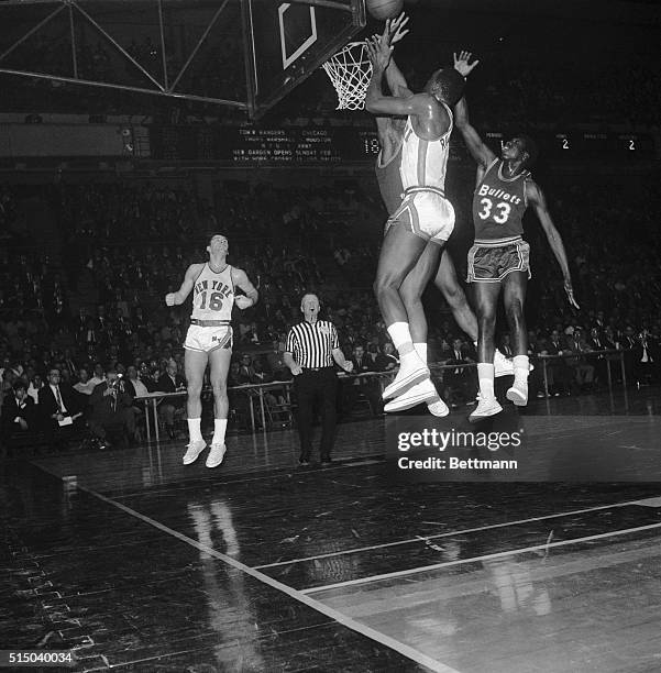 Madison Square Garden: Earl Monroe , Baltimore Bullets, vies for rebound with Cazzie Russell of the Knicks and an unidentified Baltimore player.