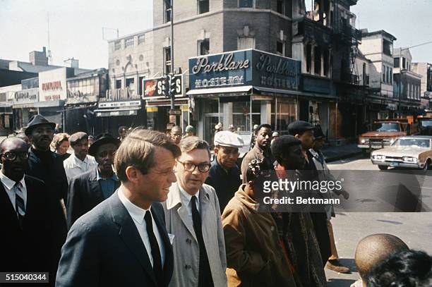 Presidential candidate Robert Kennedy strolls with African American residents of a neighborhood in Washington, DC after riots sparked by the...