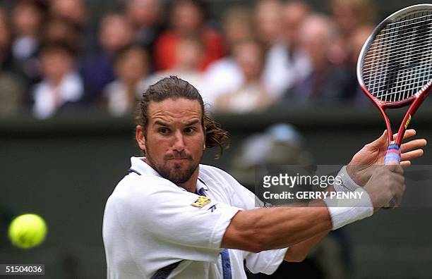Australian Patrick Rafter eyes the ball before returning a backhand slice during his semi-final match in the Wimbledon championships against US Andre...