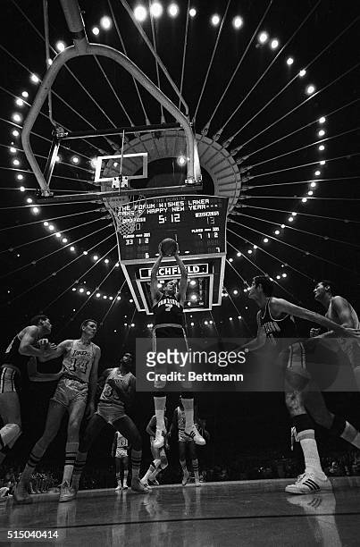 With the lights over the scoreboard forming a halo over the first NBA game played at The Forum, San Diego Rockets' Tony Kimball picks off a rebound...