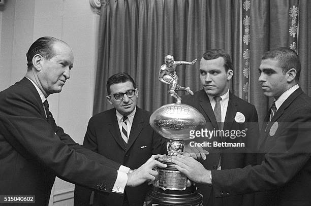 Henry L. Lambert, presents the Lambert Trophy to Penn State coach Joe Paterno, co-captain Bill Lenkaitis and captain Jim Litterelle, in ceremonies...