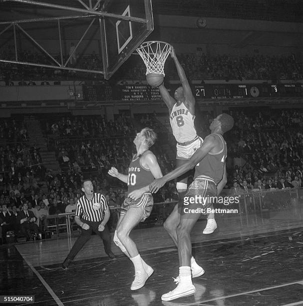 Walt Bellamy, of the New York Knicks, dunks basketball into the basket here during a game against the Baltimore Bullets.