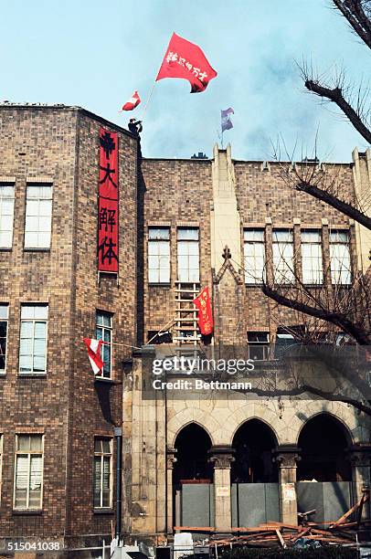 Radical student waves a flag from a tower of a building at Tokyo University, January 18, as police continue an 11-hour battle to regain the campus...