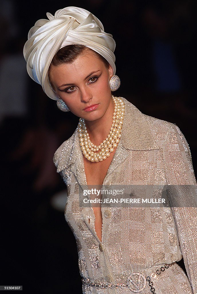 A model presents a silver knitted shirt and a white turban by Italian ...