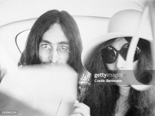 Married musicians John Lennon and Yoko Ono pictured as they drive to the airport to return to Paris after their registry office wedding here.