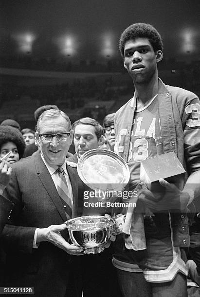 New York: Lew Alcindor shown holding the Most Valuable award over his head, with coach John Wooden of UCLA shown after victory over ST. Johns U.