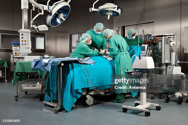 doctors and nurses operating on a patient in a operating room - operating room fotografías e imágenes de stock