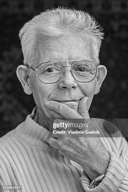 close-up portrait of happy senior man wearing glasses over black background - over 80 個照片及圖片檔