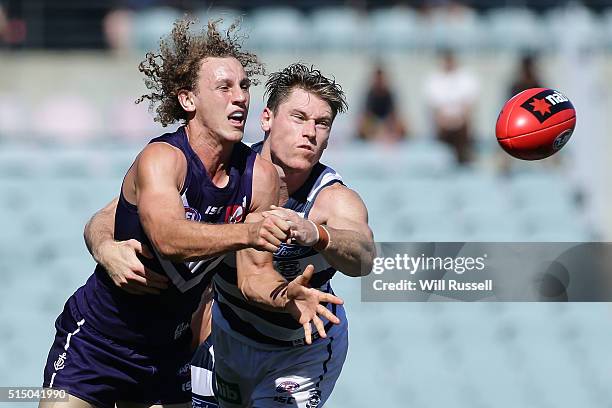 Chris Mayne of the Dockers handballs under pressure from Mark Blicavs of the Cats during the 2016 NAB Challenge match between the Fremantle Dockers...