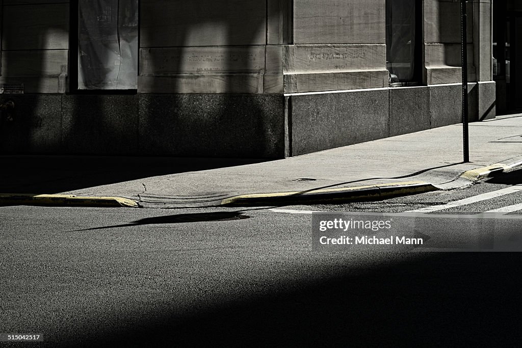 Shadowed road, pavement and building corner