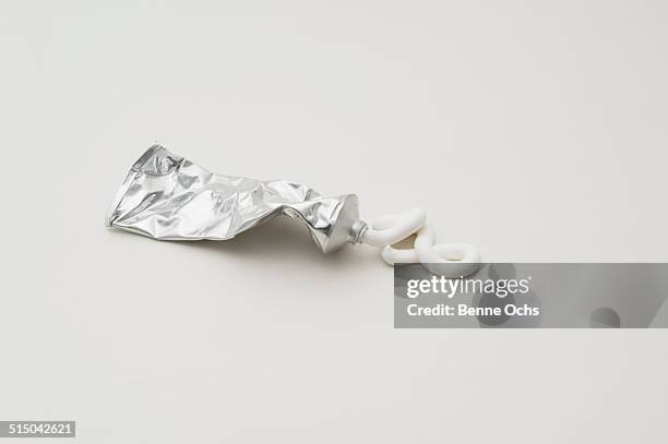 toothpaste squeezed out of tube over white background - quetschen stock-fotos und bilder