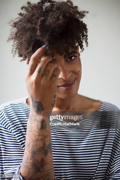 portrait of smiling young woman playing with hair against gray background - decote redondo decote - fotografias e filmes do acervo