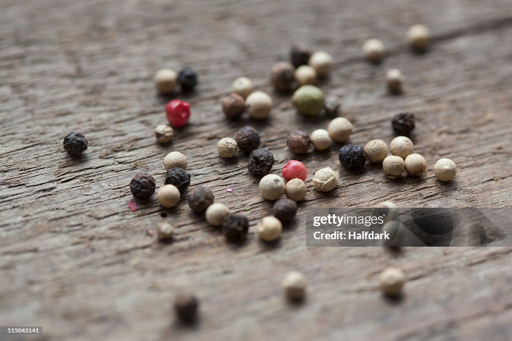 Variety of peppercorns on wooden table