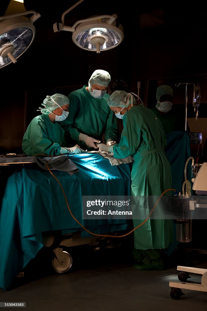 Doctors and nurses operating on a patient in a operating room