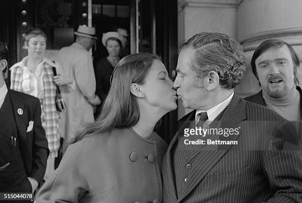 Author Norman Mailer kisses his wife outside Overseas Press Club following his press conference.
