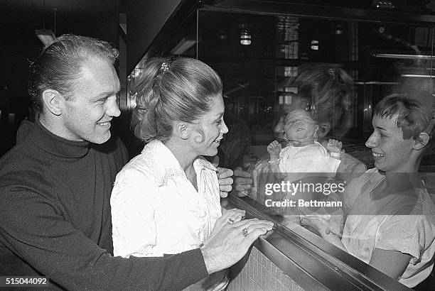 Black Hawks star Bobby Hull and his wife, Joanne, view their fourth child, a boy, at Michael Reese Hospital 2/14. The boy was born at 7 am on Feb. 13...