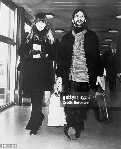 En route to Switzerland...Wearing fashions of 'today,' Beatle Ringo Starr and his wife, Maureen, walk through airport terminal here February 24th en...