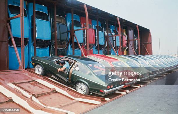Los Angeles, California: A giant railroad car which carries 30 sub-compact automobiles vertically, so they stand on end front bumper down, finished...