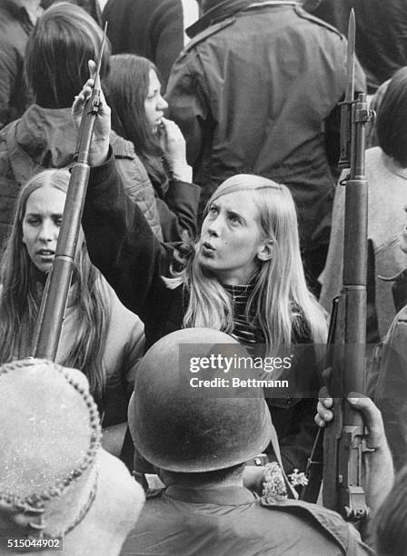 Denver: A unidentified girl protester at the University of Denver checks the sharpness of a Colorado National Guard bayonet as the guard prevented...