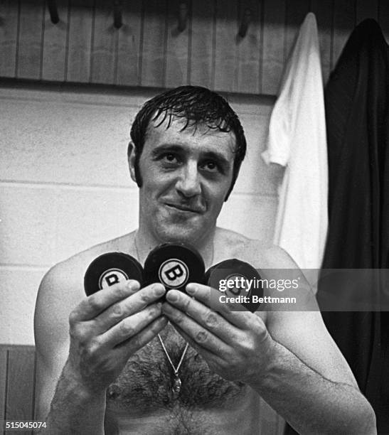 Bruins' Phil Esposito holds three pucks for the "hat trick" he scored in the first game of the Eastern NHL Stanley Cup Playoffs against the NY...