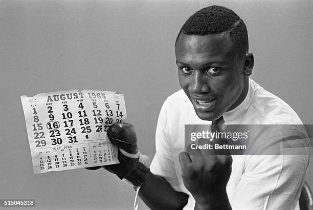 Joe Frazier, 21 year old 1964 Olympic Heavy Weight Boxing Champion, holds calendar signifying the date of his first professional fight against Roy...