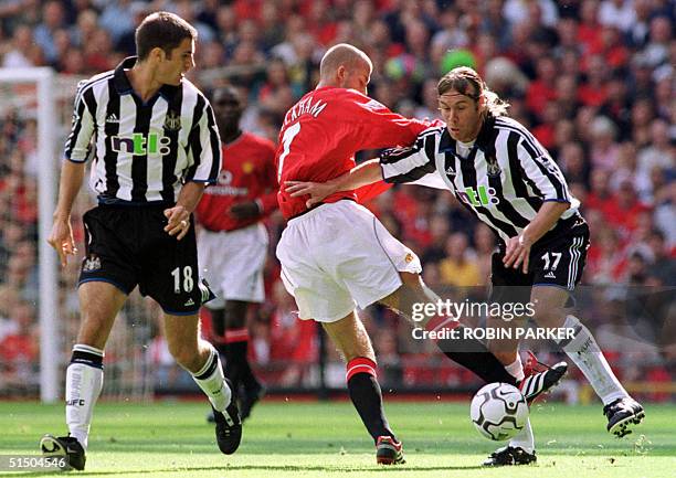 Manchester United's David Beckham fights for the ball with Daniel Cordone of Newcastle as Aaron Hughes looks on, Sunday 20 August 2000, during the FA...