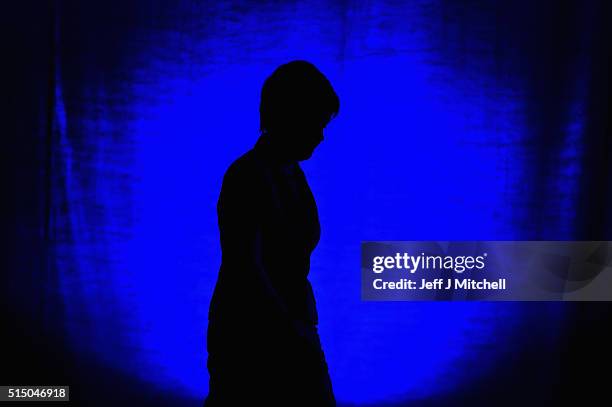 First Minister Nicola Sturgeon walks on stage to listen to Scotland's deputy first minister, John Swinney, gives the welcome address to the Scottish...