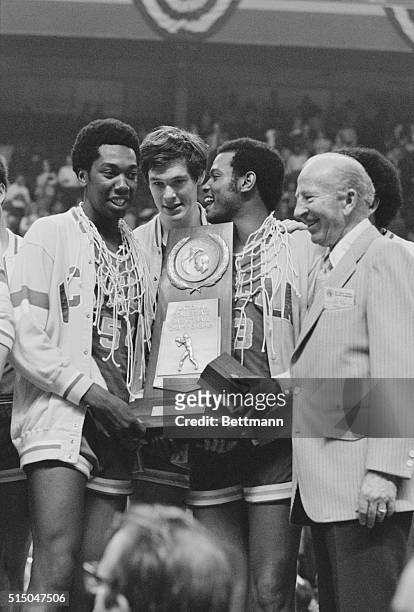 St. Louis: UCLA's Larry Hollyfield rests his arm on the NCAA championship trophy as the team posed with the trophy after UCLA won its seventh...