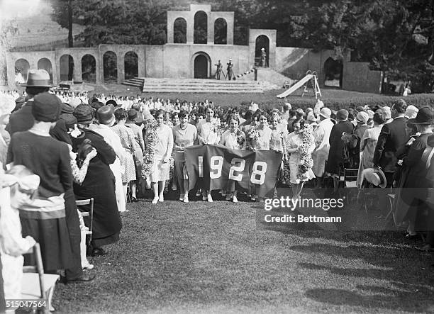 Vassar College Class Day. Seniors passing up aisles of daisy chains.