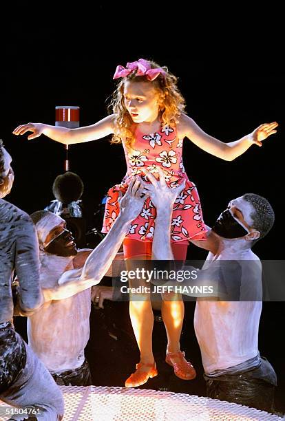 Young performer Nikki Webster is helped by unidentified performers as the show of the 15 September 2000 opening ceremonies for the Summer Olympics in...
