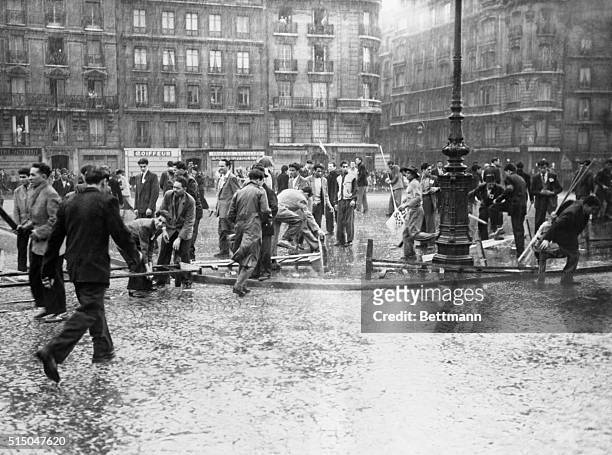 Communist demonstrators break fences apart to obtain material for clubs and other weapons useful in their attempt to disrupt France's traditional...
