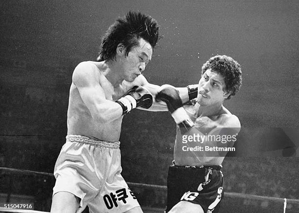 Yum Dong-kyun of South Korea and Wilfredo Gomez of Puerto Rico exchange blows in the fourth round of their world championship fight, light...