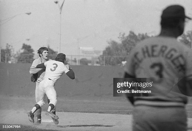 Pete Rose, of the Reds, is restrained by coach Ted Kluszewski and Johnny Bench after fight broke out near second base in 5th inning of playoff game...