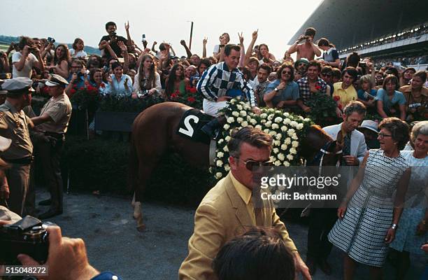 Jockey Ron Turcotte rides Secretariat into the winner's circle at the Belmont Park race track after winning the Belmont Stakes and the Triple Crown.