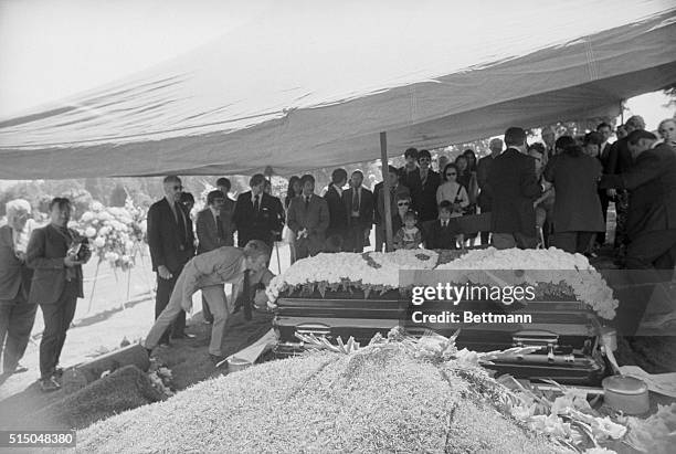 Seattle: actor Steve McQueen straightens the sign on casket at Bruce Lee's funeral. Coburn is behind Steve McQueen.