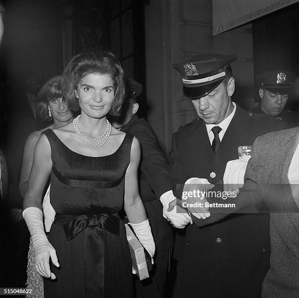 Police lock arms to hold back the curious as Jacqueline Kennedy and her sister-in-law, Mrs Peter Lawford , leave the St. Regis Hotel, June 16th,...