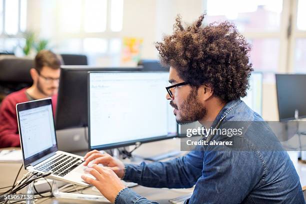 man with afro hairstyle working at his desk - founder stock pictures, royalty-free photos & images