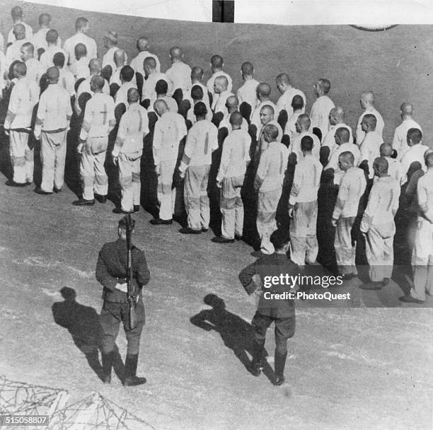 Prisoners at infamous Nazi concentration camp line up before German guards, Dachau, Poland, during World War II.