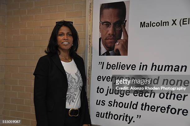 Portrait of American author Ilyasah Shabazz, daughter of Malcolm X and Betty Shabazz, as she poses beside a quote from father on a poster at Malcolm...