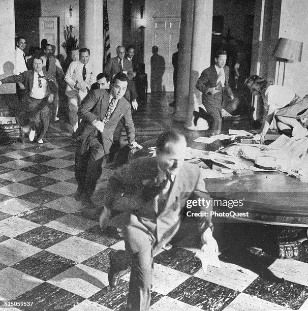 Members of the White House Press Corps rush to telephones after President Harry Truman's announcement of the surrender of Japan and the end of World...