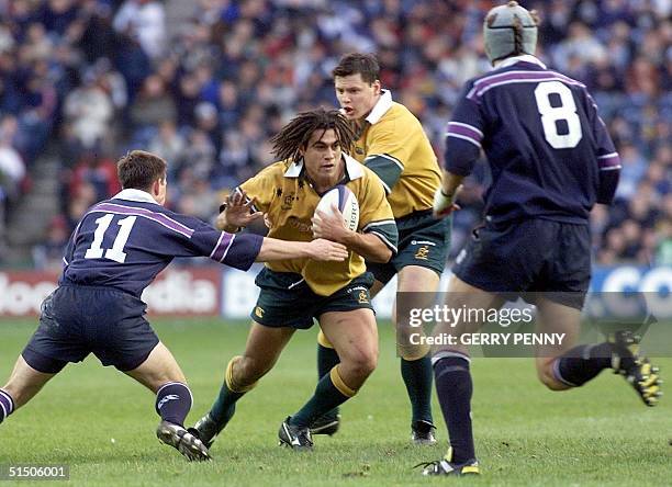 Australia's George Smith runs into the Scotland defence of Jon Steel and Simon Taylor 11 November 2000, during their Rugby Union International at...