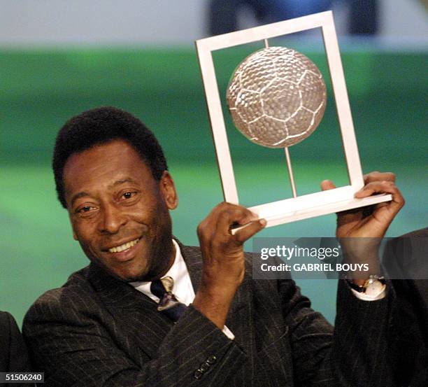 Brazilian former soccer player Pele holds his FIFA grand prix of "Footballer of the century" 11 December 2000, during the FIFA's awards ceremony gala...